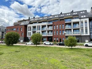 un gran edificio con coches estacionados frente a él en Apartament Widokowy Zamkowa en Tczew