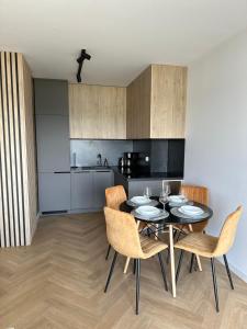 uma sala de jantar com uma mesa e cadeiras numa cozinha em Apartament Widokowy Zamkowa em Tczew