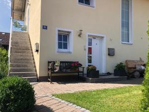 a porch of a house with a bench and stairs at Ferienwohnung mit Charme in Eurasburg