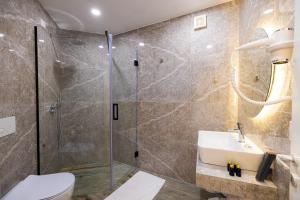 a bathroom with a shower and a toilet and a sink at PATIO MARE in Dhërmi +37 photos