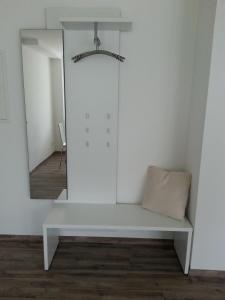 a white bench in a room with a mirror at Teck-Apartment in Kirchheim unter Teck