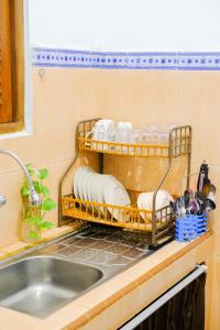 a kitchen sink with a dish drying rack next to it at ROOM Ijen Dormitory & Tours in Banyuwangi