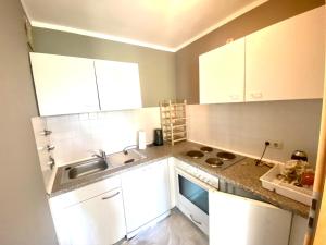 a small kitchen with white cabinets and a sink at BER, Quiet, Green, View, near Terminal, Berlin parking in Schönefeld