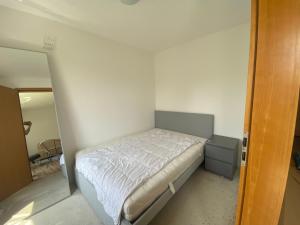 a small bedroom with a bed with white sheets at BER, Quiet, Green, View, near Terminal, Berlin parking in Schönefeld