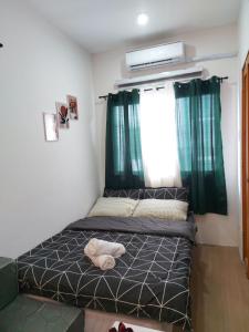 a bed in a room with green curtains at Fully Furnished Staycation - Neflix, Pool,Can cook near Mactan Airport in Maribago