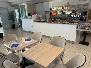 a restaurant with tables and chairs and a counter at Hotel Abamar in Rimini