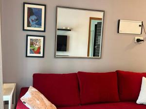 a red couch in a living room with a mirror at Pali Carters Building 102, 20th Road, Khar West by Connekt Homes in Mumbai
