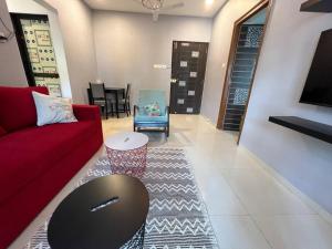 a living room with a red couch and a table at Pali Carters Building 102, 20th Road, Khar West by Connekt Homes in Mumbai