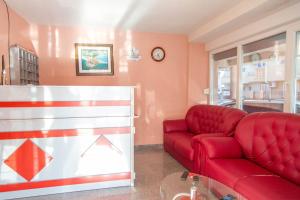 a living room with a red couch and a table at Vila Vrba in Donji Štoj