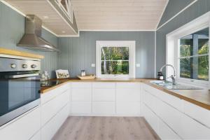 cocina grande con armarios blancos y ventana en Cabin in Malangen, en Mestervik