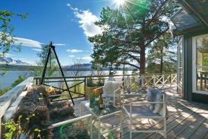 een terras met stoelen en een tafel en uitzicht op het water bij Cabin in Malangen in Mestervik