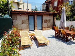 une terrasse avec des chaises, une table et un parasol dans l'établissement Casa da Florbela, à Fafe