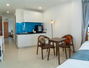 a bedroom with a table and two chairs and a kitchen at Ha Trang Voronezh Hotel and Apartment in Nha Trang