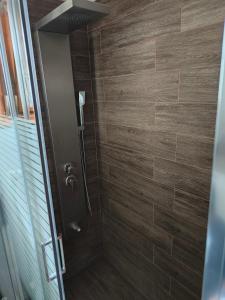 a bathroom with a shower with wooden tiles at The Cozy Garden Villa 