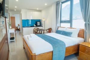 a bedroom with a large bed with a large window at Ha Trang Voronezh Hotel and Apartment in Nha Trang