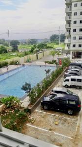 una vista de una piscina con coches aparcados en un aparcamiento en Collin Space 314 en Tunkong Manga