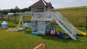 a playground with a slide and a play house at Apartamenty Tylicki Poranek in Tylicz