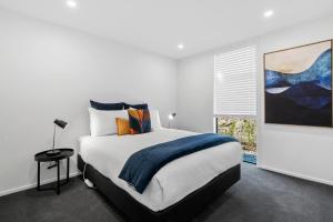 een witte slaapkamer met een groot bed en een raam bij A Remarkable Stay - Jack's Point Holiday Home in Queenstown