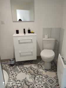 a bathroom with a white toilet and a sink at Le Petit Cosy in Saint-Front-la-Rivière