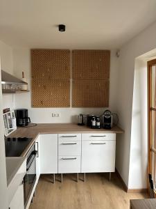 a kitchen with white cabinets and a wooden floor at Seeapartment in Prien am Chiemsee