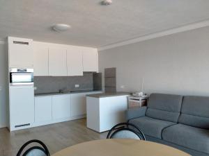 a kitchen and a living room with a couch and a table at Residentie Romanza in Middelkerke