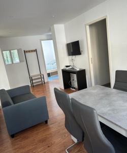 a living room with a table and chairs and a television at Appartement T4 des jardins in Chambéry
