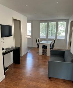 a living room with a couch and a table at Appartement T4 des jardins in Chambéry