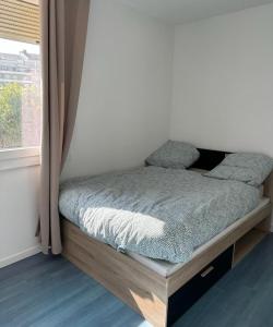 a small bed in a room with a window at Appartement T4 des jardins in Chambéry