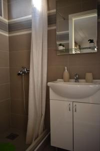 a bathroom with a sink and a shower curtain at Petković apartman in Bajina Bašta