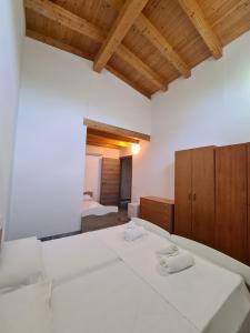 1 Schlafzimmer mit 2 weißen Betten und Holzdecken in der Unterkunft Agriturismo Ca Novak Venezia in Spinea