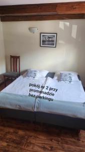 a bed with a sign on it in a bedroom at Syrenka Apartamenty in Ustka