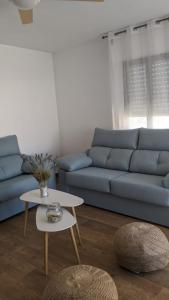 a living room with a blue couch and a table at CABALLITO DE MAR in Los Alcázares