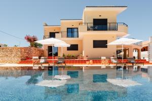 a house with a swimming pool with chairs and umbrellas at VILLA DOS R'S in Avis