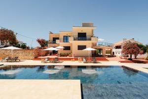 a swimming pool in front of a building with umbrellas at VILLA DOS R'S in Avis