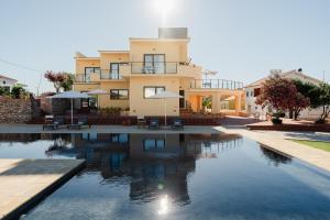 a house with a swimming pool in front of a building at VILLA DOS R'S in Avis