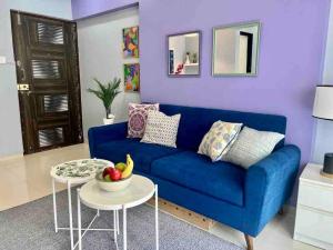 Pali Carters Building 801, 20th Road, Khar West by Connekt Homes في مومباي: أريكة زرقاء في غرفة المعيشة مع طاولة