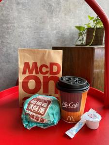 een McDonalds tas en een kop koffie op een rode tafel bij Jin Spa Resort Hotel in Jinshan
