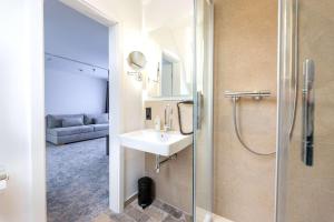 a bathroom with a sink and a shower at Hotel Südblick in Norderney