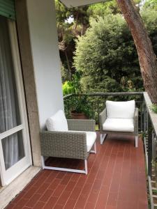 a porch with two chairs and a window at Endless Summer in Viareggio