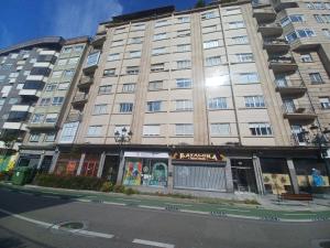 a tall building on a city street with a building at APARTAMENTO VIGO CAMELIAS CENTRO in Vigo
