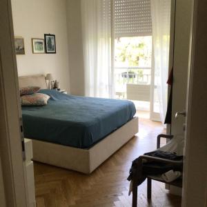 een slaapkamer met een bed en een groot raam bij Endless Summer in Viareggio