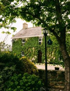 an ivycovered house with a street light in front of it at Fitz Of Inch - Self Catering House and Barns in Stradbally