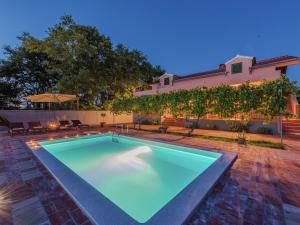 una piscina en medio de un patio con un edificio en Charming holiday home with private pool en Donji Zemunik