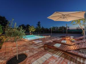 a patio with an umbrella and a swimming pool at Charming holiday home with private pool in Donji Zemunik