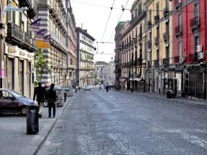 Une rue urbaine vide avec des gens qui marchent dans la rue dans l'établissement Maison Dante, à Naples