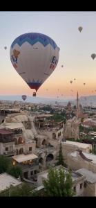 a hot air balloon flying over a city at Göreme Escape Cave Suites in Goreme