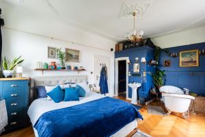 a blue bedroom with a bed and a bath tub at Victoria Design Stays - Premium Apartment Ohrada in Prague