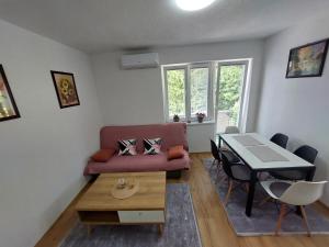 uma sala de estar com um sofá e uma mesa em Apartman "MEDENI" em Bihać
