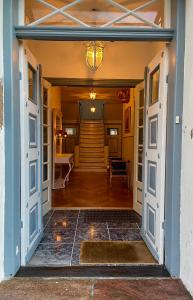 uma porta aberta de uma casa com uma escada em Boutique Hotel Postgården em Holsted