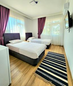 a hotel room with two beds and a television at Asimado Hotel in Antalya